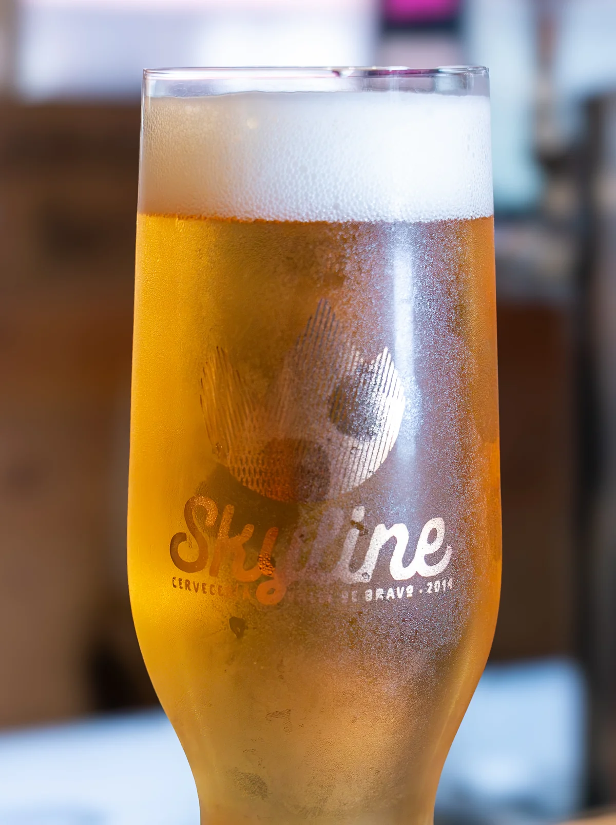 Cascarita — Blonde Ale, pint dorada sobre barra de madera live edge