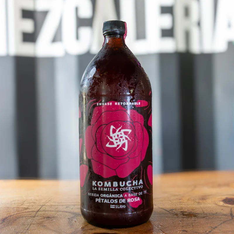 Botella oscura de kombucha La Semilla Colectivo de 1 litro, etiqueta de rosa magenta, sabor pétalos de rosa